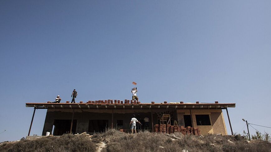 Men work on the roof of a house under construction in the unauthorised Jewish settler outpost of Havat Gilad, south of the West Bank city of Nablus November 5, 2013. Israeli and Palestinian officials said on Tuesday the three-month-old peace talks pressed on them by Washington are going nowhere, painting a grim picture for a visit this week by U.S. Secretary of State John Kerry. Both sides have been airing their frustration over a lack of progress in the U.S.-brokered talks aimed at resolving core issues su