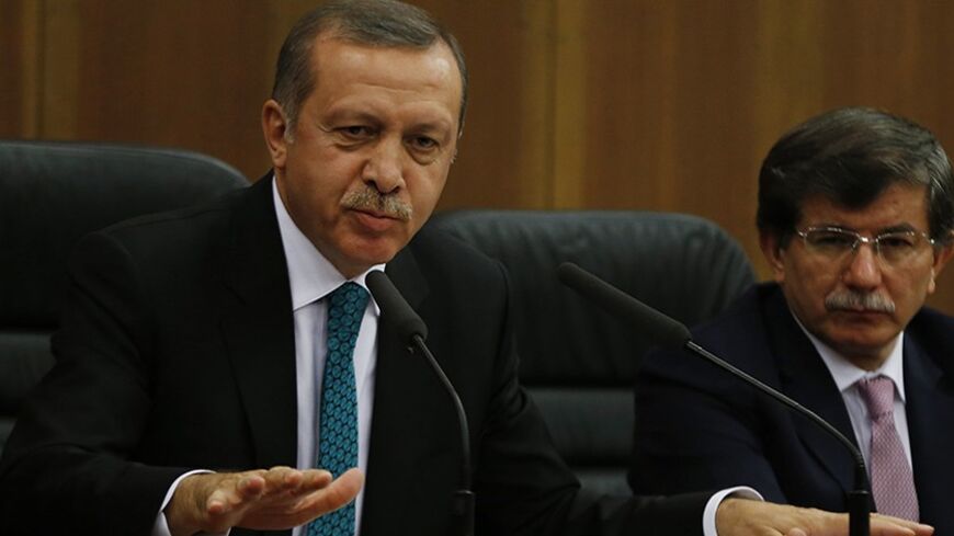 Turkish Prime Minister Tayyip Erdogan addresses the media next to Foreign Minister Ahmet Davutoglu (R) at Esenboga Airport in Ankara November 21, 2013. A feud between Erdogan and an influential Islamic cleric, Fethullah Gulen, has spilled into the open months ahead of elections, highlighting fractures in the religiously conservative support base underpinning his decade in power. REUTERS/Umit Bektas (TURKEY - Tags: POLITICS RELIGION) - RTX15NGG