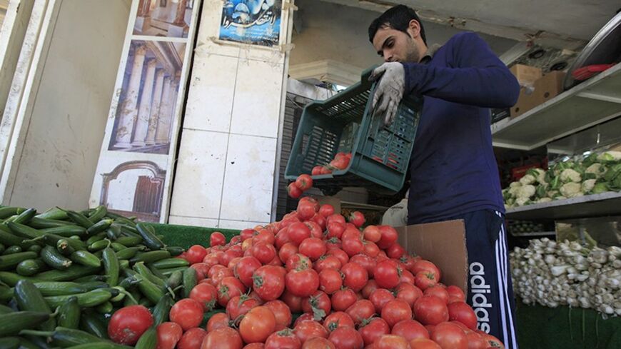A vendor pours tomatoes out to display while waiting for customers at a greengrocer's shop in Baghdad January 16, 2014. The day after one of Iraq's bloodiest days for months, shoppers and drivers packed the streets of Baghdad on Thursday, grimly aware that death can strike anywhere, any time. At least eight bombs hit the capital, mostly in Shi'ite districts, on Wednesday, killing 40 people and wounding 88, while attacks elsewhere pushed the national death toll to 78. REUTERS/Ahmed Saad (IRAQ - Tags: SOCIETY