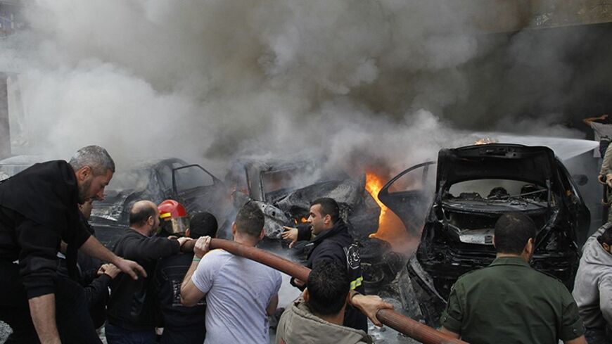 Firefighters extinguish a fire from burning cars at the site of an explosion in the Haret Hreik area, in the southern suburbs of the Lebanese capital Beirut January 21, 2014. A suicide bomber killed four people on Tuesday in the residential neighbourhood of southern Beirut known for its support of Shi'ite military and political group Hezbollah, security sources said. REUTERS/Stringer (LEBANON - Tags: POLITICS CIVIL UNREST) - RTX17NZH