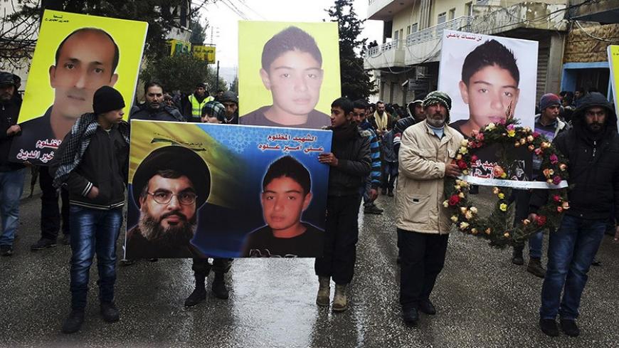 Friends and family members of victims killed in a car bomb attack on Saturday, hold a wreath along with their pictures during a funeral in the Shi'ite town of Hermel February 3, 2014. A suicide car bomber killed three people at a petrol station in a stronghold of the Shi'ite militant Hezbollah movement on Lebanon's northern border on Saturday, the latest sign that Syria's civil war is spilling over into its small neighbour. Hezbollah leader Sayyed Hassan Nasrallah is pictured on the left in the banner in fr