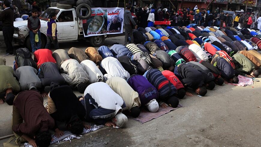 Supporters of the Muslim Brotherhood and ousted Egyptian President Mohamed Mursi pray on the street during a protest against the military and interior ministry around Ain Shams square in east Cairo February 7, 2014. Two explosive devices detonated on Friday near a police checkpoint in Giza, on the outskirts of Cairo, wounding six people, the government and security sources said. REUTERS/Amr Abdallah Dalsh (EGYPT - Tags: POLITICS CIVIL UNREST) - RTX18CZM