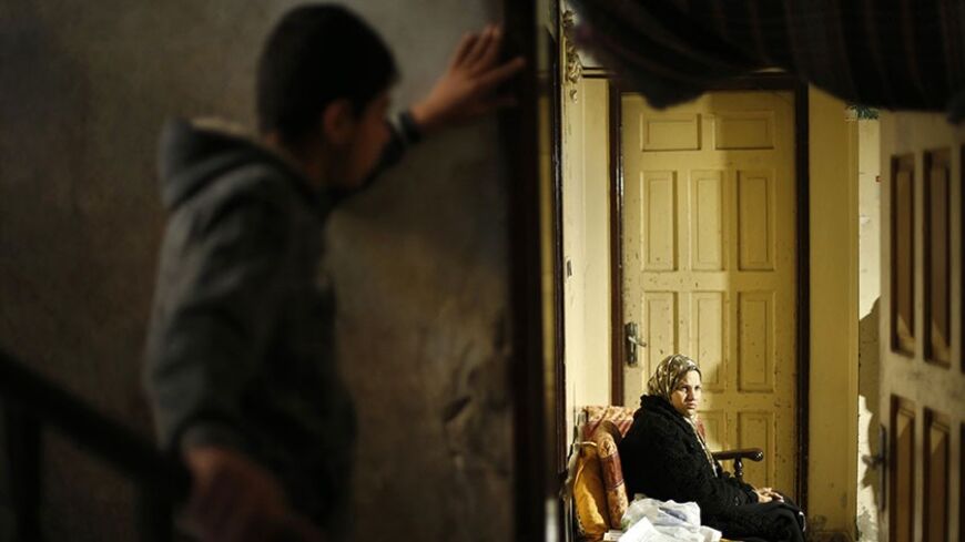 Suhad al-Katib, a Palestinian woman patient who suffers cancer sits inside her house after she was not allowed to enter Israel, in Gaza City February 12, 2014. Israel has denied entry permits to some 50 Palestinian medical patients from the Gaza Strip because the words "State of Palestine" appears on the letterhead of their application, officials said on Wednesday. REUTERS/Mohammed Salem (GAZA - Tags: POLITICS CIVIL UNREST HEALTH) - RTX18O7O