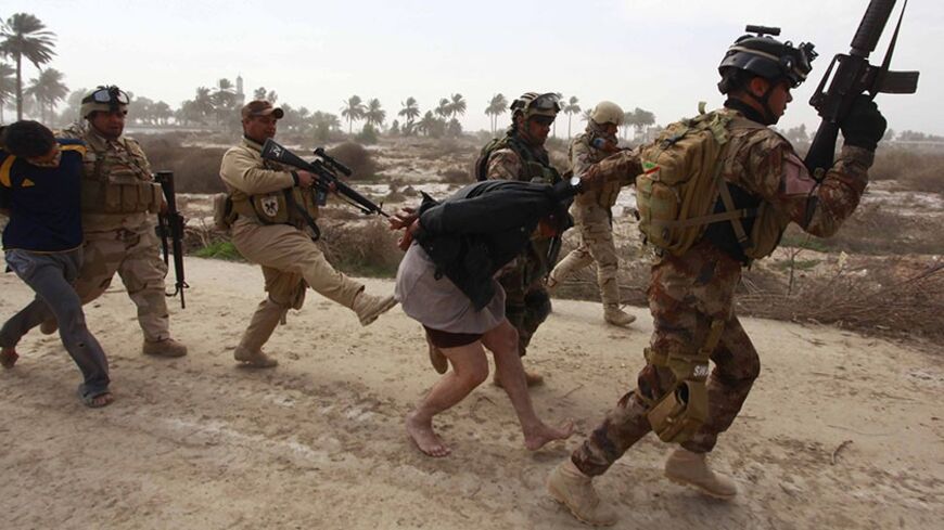 Personnel from the Iraqi security forces arrest suspected militants of the al Qaeda-linked Islamic State in Iraq and the Levant (ISIL), during clashes with Iraqi security forces in Jurf al-Sakhar, 60 km (40 miles) from the capital February 15, 2014. South of Baghdad, ISIL militants killed at least eight soldiers in overnight clashes in Jurf al-Sakhar, 60 km (40 miles) from the capital, army and police sources said. REUTERS/Alaa Al-Marjani (IRAQ - Tags: CIVIL UNREST CRIME LAW MILITARY TPX IMAGES OF THE DAY)