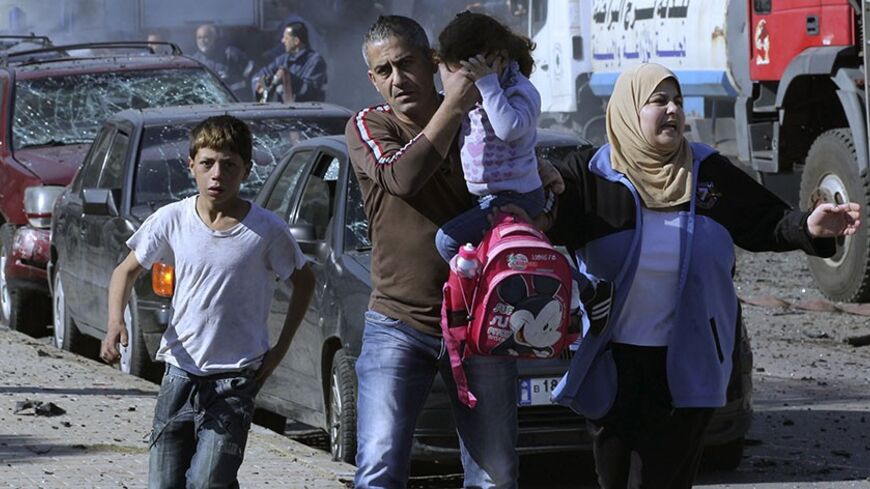 Civilians run from the site of an explosion in the southern suburbs of Beirut February 19, 2014. A large explosion near an Iranian cultural centre in the southern suburbs of Lebanon's capital Beirut on Wednesday killed at least four people and wounded 19, security sources said. Security sources said the explosion appeared to have been caused by a car bomb and a motorcycle laden with explosives. REUTERS/Mahmoud Kheir   (LEBANON - Tags: POLITICS CIVIL UNREST) - RTX1937S