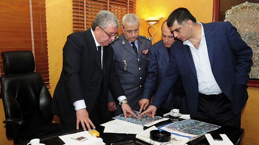 Lebanese Interior Minister Nouhad al-Mashnouq (L), Acting Director General of the Internal Security Forces Major General Ibrahim Basbous (2nd L) and head of the Internal Security Force's Information Branch Colonel Imad Othman (R) inspect a map at the ISF headquarters to locate the site of the explosion that occured near the Iranian cultural centre in the southern suburbs of Beirut February 19, 2014. The al Qaeda-linked Abdullah Azzam Brigades claimed a twin bomb attack in Beirut on Wednesday, saying such at
