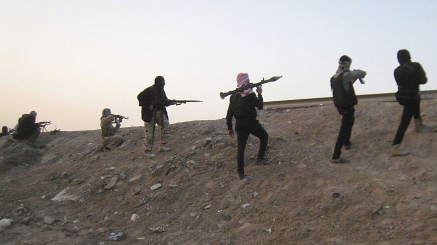Masked Sunni Muslims gunmen take up position with their weapons during clashes with Iraqi security forces outside the city of Falluja, 70 km (44 miles) west of Baghdad, February 23, 2014.  Members of the extremist Islamic State in Iraq and the Levant are holed up inside Fallujah along with Sunni fighters angry at Prime Minister Nouri Maliki over what they say are policies which discriminate against Iraq's Sunni minority. The Iraqi government declared a ceasefire over the weekend but clashes flared periodica