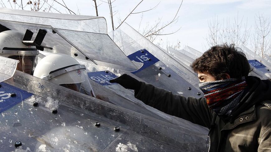 A student argues with riot police during a protest against Prime Minister Tayyip Erdogan at the Middle East Technical University (ODTU) in Ankara December 15, 2010. Erdogan was at the university to attend a meeting. REUTERS/Umit Bektas (TURKEY - Tags: POLITICS CIVIL UNREST IMAGES OF THE DAY) - RTXVQL4
