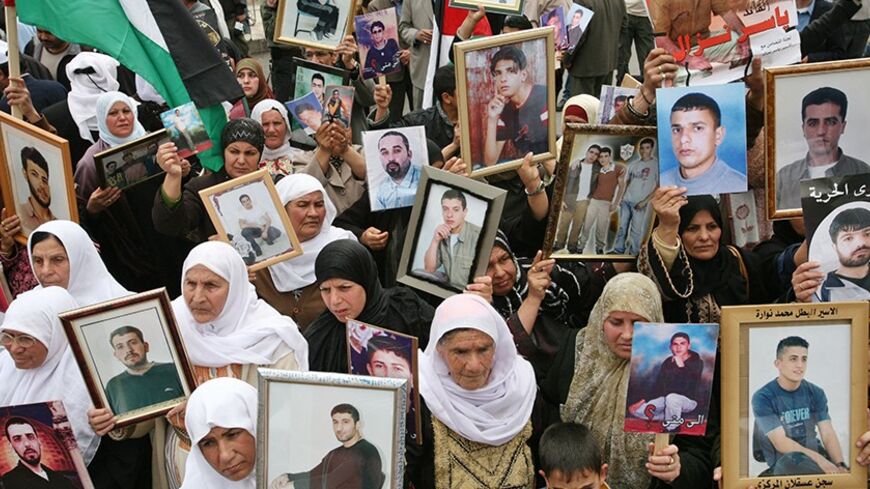 Palestinian women hold pictures of jailed relatives during a protest marking "Palestinian Prisoners Day" in the West Bank town of Ramallah April 17, 2007. The women were calling for the release of Palestinian prisoners in Israeli jails. Palestinian Prime Minister Ismail Haniyeh said on Monday that Marwan Barghouthi, a Palestinian uprising leader, is on a list of prisoners the Hamas movement demands Israel release in exchange for a captive soldier. REUTERS/Oleg Popov (WEST BANK) - RTR1OPVW