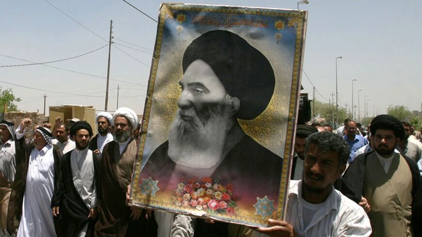 Iraqis carry a poster of top Shi'ite cleric Grand Ayatollah Ali al-Sistani during a demonstration in Najaf, 160 km (100 miles) south of Baghdad June 13, 2007. Dozens of residents took to the streets in Najaf protesting the latest bomb attack in Samarra's Golden Mosque Shi'ite shrine.     REUTERS/Ali Abu Shish    (IRAQ) - RTR1QQY3