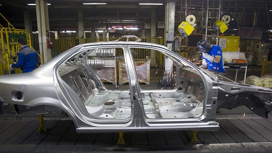 An Iranian worker works on a production line of carmaker Iran Khodro, west of Tehran June 20, 2011.  Unusually for the Middle East, Iran has developed its domestic car industry for five decades and produced 1.6 million vehicles last year, about half of them made by Iran Khodro which aims to export around 10 percent of its production this year. Even with sanctions, which have scared off some suppliers from exporting to Iran, and a limp economy, Iran Khodro says sales rose 18 percent in 2010 and plans a 13 pe
