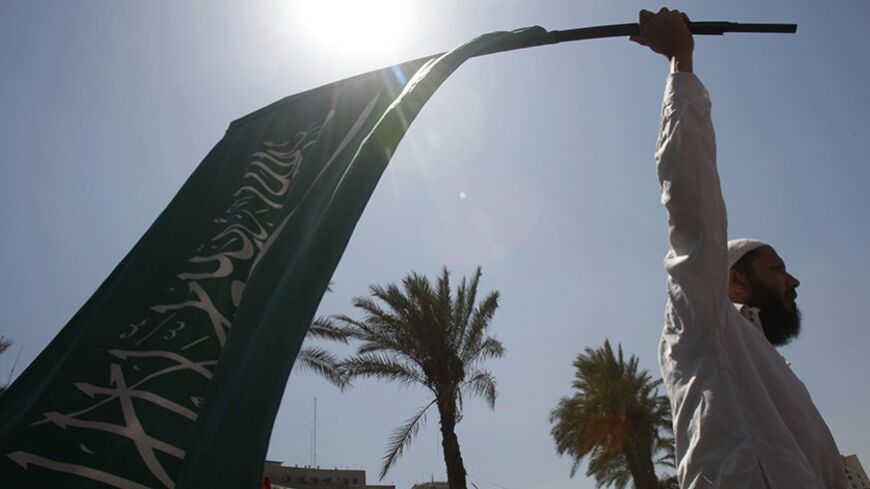An Egyptian protester waves a Saudi Arabia flag at Tahrir square in Cairo July 29, 2011. Thousands of Egyptians gathered in Cairo's Tahrir Square on Friday to show Islamists and others were united in wanting change, though divisions remain on how hard to press the military rulers about the pace and depth of reforms. Muslim chants such as "There is no God but God" and "Islamiya, Islamiya" dominated. Some waved banners saying "Islamic Egypt." A senior Muslim Brotherhood official described the rally as a "Frid