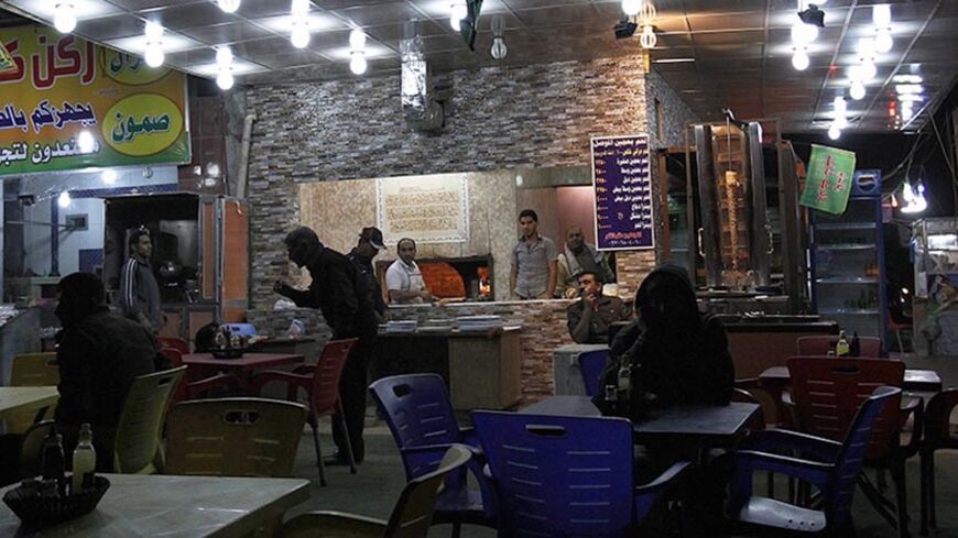 People sit outside a cafe in Baghdad December 1, 2011. The last 13,000 U.S. troops will pull out of Iraq by the end of the year. Violence in the country has dropped sharply since the heights of sectarian slaughter in 2006-2007, but at least 10 people were killed in a bombing just north of the capital Baghdad.   REUTERS/Shannon Stapleton   (IRAQ - Tags: MILITARY CONFLICT SOCIETY) - RTR2UPPL