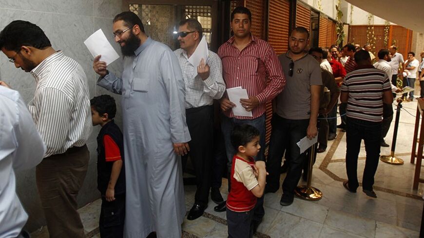 Egyptian expatriates living in Qatar wait for their turns to vote at a polling station at the Egyptian embassy in Doha May 12, 2012, during an early voting ahead of Egypt's presidential election. Egypt's presidential election, set to be the freest it has ever had, began for citizens abroad on Friday after a caustic televised debate between two candidates that produced no clear favourite to lead the most populous Arab nation. With no obvious winner for now, the fewer than 1 million expatriates registered to