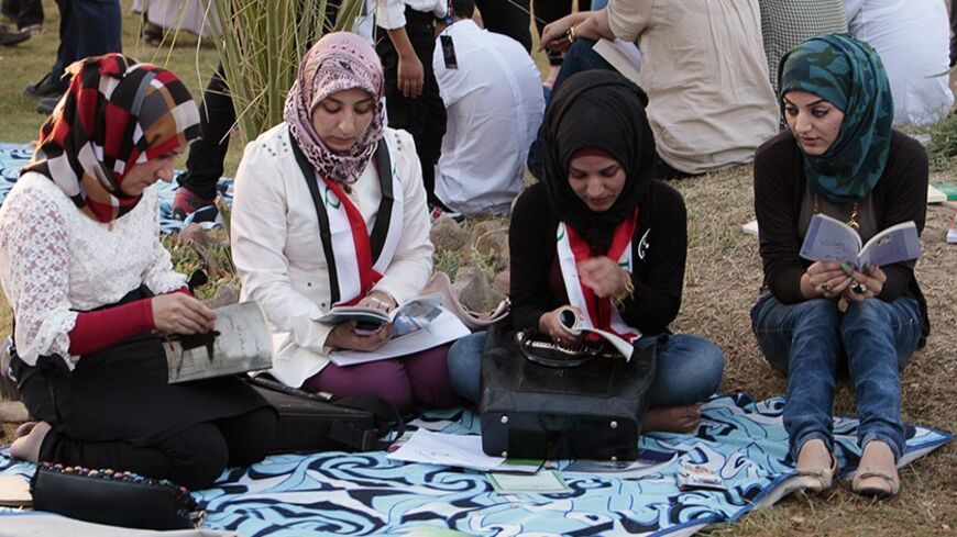 People browse through books during the launch of a reading initiative in Abu Nawas Park in Baghdad September 28, 2013. The "I am Iraqi... I read" initiative was launched on Saturday in Baghdad to encourage Iraqis to read in a country that has suffered decades of war and internal struggle. REUTERS/Ahmed Saad (IRAQ - Tags: EDUCATION SOCIETY) - RTR3FE1M