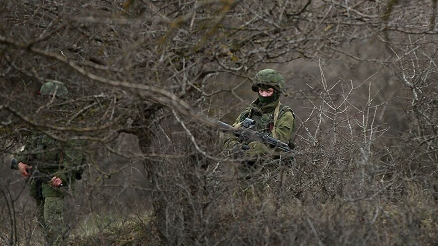Military personnel, believed to be Russian servicemen, stand guard outside the territory of a Ukrainian military unit in the village of Perevalnoye outside Simferopol March 4, 2014. Russian President Vladimir Putin delivered a robust defence of Russia's actions in Crimea on Tuesday and reserved the right to use force in Ukraine as a last resort, but he sought to ease East-West tension over fears of war in the former Soviet republic.  REUTERS/David Mdzinarishvili (UKRAINE - Tags: POLITICS MILITARY CIVIL UNRE