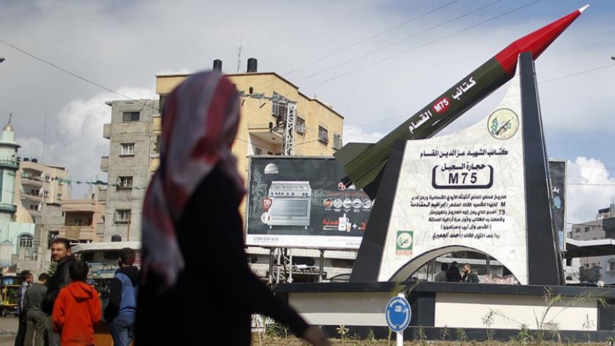 A Palestinian girl walks past a monument of a homemade M75 rocket in the middle of a square in Gaza City March 10, 2014. Hamas fired M75 rockets at Tel Aviv and Jerusalem in the 2012 eight-day fighting with Israel. REUTERS/Mohammed Salem (GAZA - Tags: POLITICS CIVIL UNREST) - RTR3GEHZ