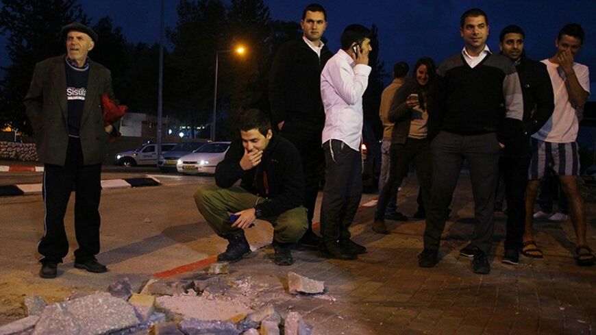 Israeli onlookers survey the damage caused by a rocket which was fired from the Gaza Strip and landed in the southern Israeli town of Sderot March 12, 2014. Palestinian militants in the Gaza Strip fired at least 20 rockets into Israel on Wednesday, the Israeli military said, in the heaviest such barrage in two years. REUTERS/Ilan Assayag (ISRAEL - Tags: POLITICS CIVIL UNREST) ISRAEL OUT. NO COMMERCIAL OR EDITORIAL SALES IN ISRAEL - RTR3GSN7