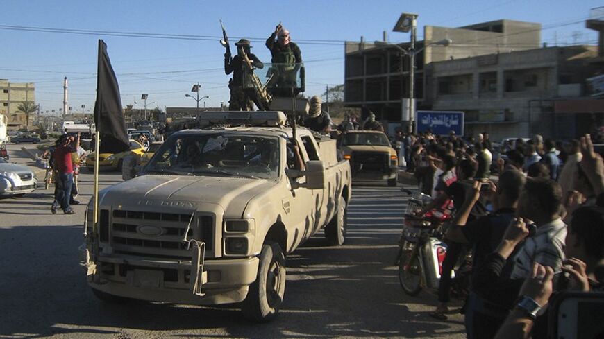 Al Qaeda fighters celebrate on vehicles taken from Iraqi security forces on a main street in Fallujah, 70 km (43 miles) west of Baghdad, March 20, 2014. Iraq's Shi'ite-led government has been battling al Qaeda faction, the Islamic State of Iraq and the Levant (ISIL), around the cities of Ramadi and Fallujah in western Anbar province. REUTERS/Stringer (IRAQ - Tags: CIVIL UNREST POLITICS CONFLICT) - RTR3HXS9