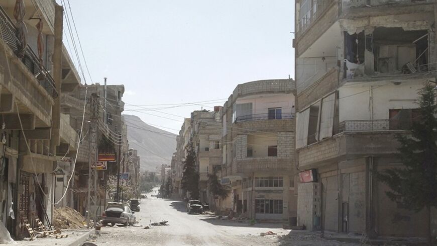Damages are seen on a street at Yabroud town in Damascus countryside March 20, 2014, after soldiers loyal to President Bashar al-Assad took control of it from the rebel fighters. REUTERS/Khaled al-Hariri (SYRIA - Tags: POLITICS CONFLICT CIVIL UNREST) - RTR3HYPI