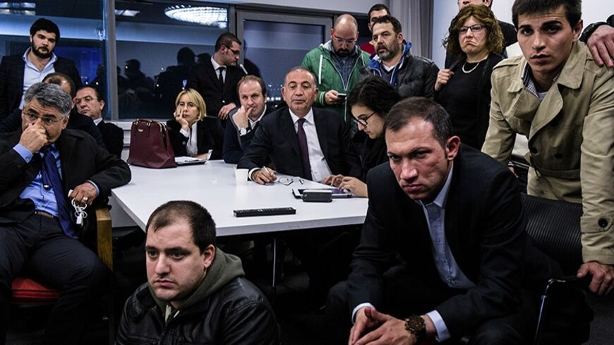 Gursel Tekin (C), main opposition Republican People's Party (CHP) deputy chairman, watches election results on TV with party members at the CHP headquarters in Ankara late March 30, 2014. Tayyip Erdogan's ruling AKP party appeared on Sunday to be heading for a clear victory in local polls that have become a referendum on a prime minister facing corruption scandals and security leaks he blames on "traitors" embedded in state bodies. With about half of votes counted, results cited on Turkish television put hi