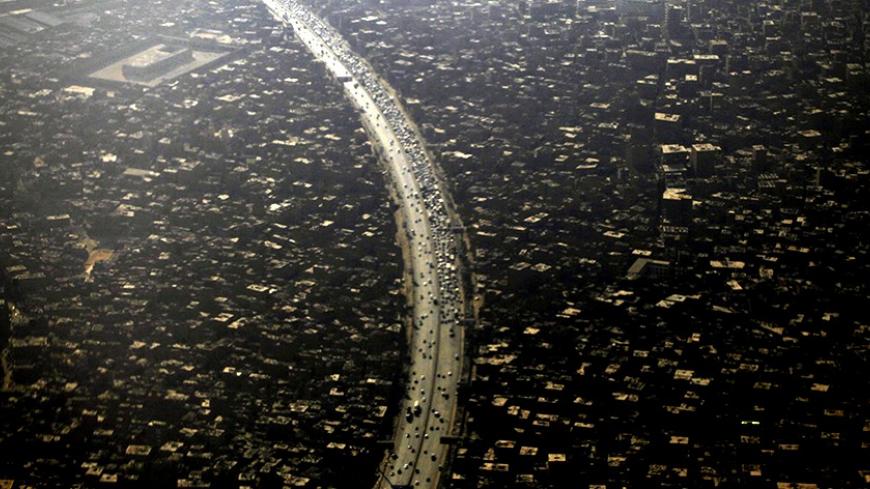 An aerial view of Cairo's traffic and houses is pictured through the window of an airplane September 11, 2013. Egypt's population has reached 85 million with the Cairo governorate coming in with the highest number at 8.9 million people, according to the Central Agency for Public Mobilization and Statistics (CAPMAS). REUTERS/Amr Abdallah Dalsh  (EGYPT - Tags: CITYSCAPE) - RTX13HWO