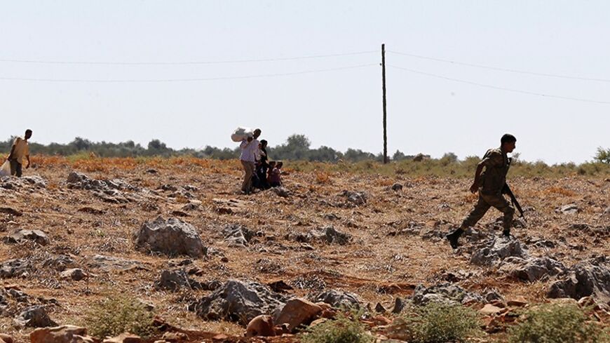 A Turkish soldier runs after Syrians passing into Turkey from over the border with Syria from the wire fences illegally near Turkish border village of Besaslan, Hatay province, September 11, 2013. Picture taken September 11, 2013. REUTERS/Umit Bektas (TURKEY - Tags: POLITICS CONFLICT SOCIETY IMMIGRATION MILITARY) - RTX13JSX