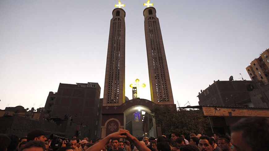 People gather at the Virgin Church for the funeral of four victims killed in an attack at a wedding on Sunday, in Cairo October 21, 2013. Egyptian Coptic Christians joyfully waited outside the Virgin Church in Cairo for the bride to arrive to join the groom for their wedding. Instead bearded men on a motorcycle pulled up and fired on the crowd, deepening the fears of many Christians that their minority community will pay the bloodiest price for the ouster of elected Islamist President Mohamed Mursi. The bri