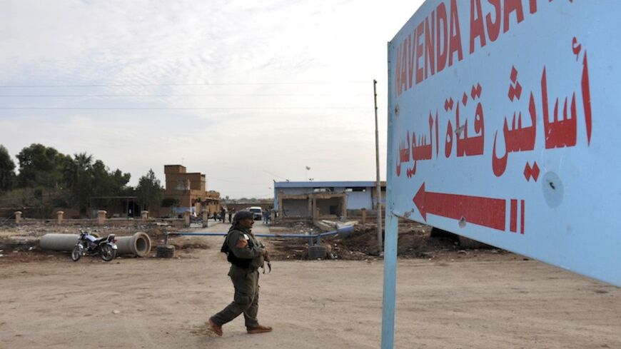 A member of the Asayish carries his weapon as he secures the area hit by a suicide bombing on Saturday at the Kurdish Security Forces Center (Asayish) at the Suez Canal neighbourhood in Qamishli November 25, 2013. The al-Qaeda linked Islamic State of Iraq and the Levant have claimed responsibility for the bombing which killed three people, including two members of the Asayish police force, and nine others wounded, activists said. Picture taken November 25, 2013. REUTERS/Rodi Said (SYRIA - Tags: POLITICS CIV