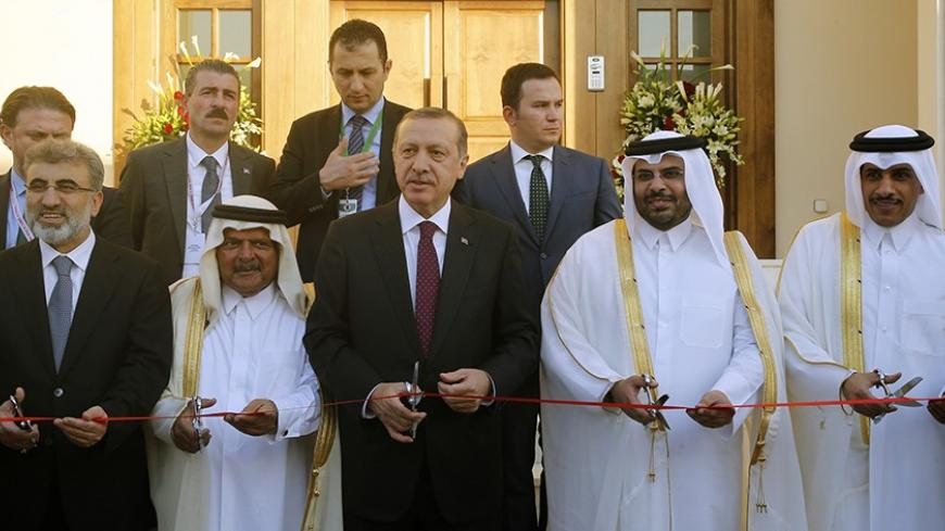 Turkey's Prime Minister Tayyip Erdogan (C) cuts the ribbon during the opening ceremony of the new building of the Turkish Embassy in Doha December 4, 2013. REUTERS/Mohammed Dabbous (QATAR - Tags: POLITICS) - RTX163G5