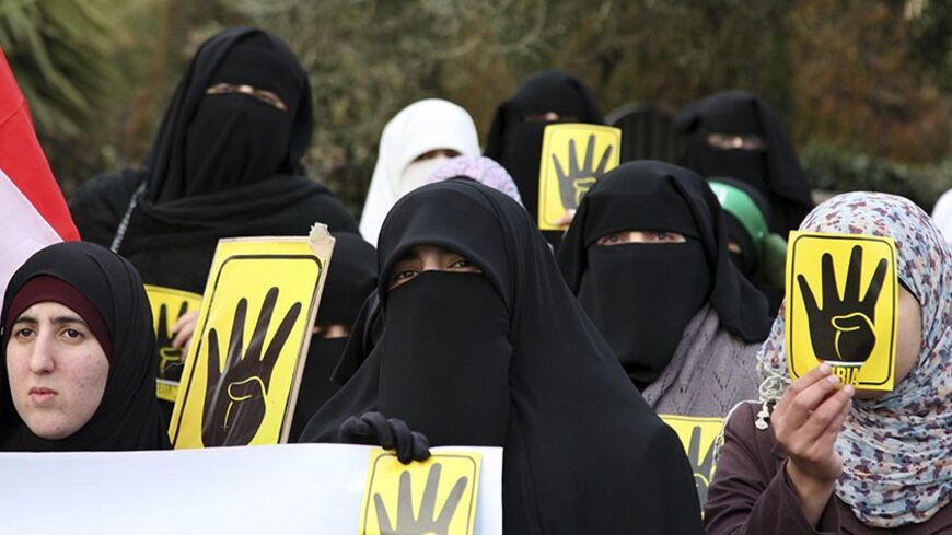 Jordanian Muslim Brotherhood protesters make the 'four-fingered salute' during a protest against the Egyptian Defense Minister Abdel Fattah al-Sissi as they mark the third anniversary of the revolution, in front of the Egyptian embassy in Amman January 25, 2014. REUTERS/Majed Jaber (JORDAN - Tags: POLITICS CIVIL UNREST) - RTX17U9J