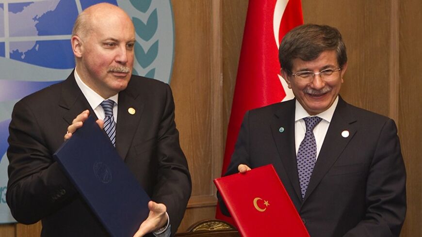 Turkey's Foreign Minister Ahmet Davutoglu (R) and Secretary-General of Shanghai Cooperation Organisation (SCO) Dmitry Mezentsev show signed documents granting Turkey a partner status in SCO, in Almaty April 26, 2013. REUTERS/Shamil Zhumatov (KAZAKHSTAN - Tags: POLITICS BUSINESS) - RTXZ0S8
