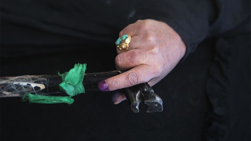 A woman with ink-stained fingers, holds a walking stick at a polling station in Baghdad's Sadr City March 7, 2010. Polling stations opened in Iraq on Sunday for a parliamentary election seen as crucial to the future of a country seeking stability after years of bloodshed. REUTERS/Thaier Al-Sudani  (IRAQ - Tags: POLITICS ELECTIONS) BEST QUALITY AVAILABLE - RTR2CEG2