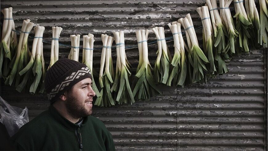 EDITORS' NOTE: Reuters and other foreign media are subject to Iranian restrictions on leaving the office to report, film or take pictures in Tehran.

A vendor hangs vegetables in front of a shop in a bazaar in northern Tehran February 29, 2012. For months now, Iranians have endured economic hardship, political repression and international isolation as the authorities refuse to halt sensitive nuclear work as demanded by the U.N. Security Council. REUTERS/Morteza Nikoubazl (IRAN - Tags: POLITICS ELECTIONS SOC
