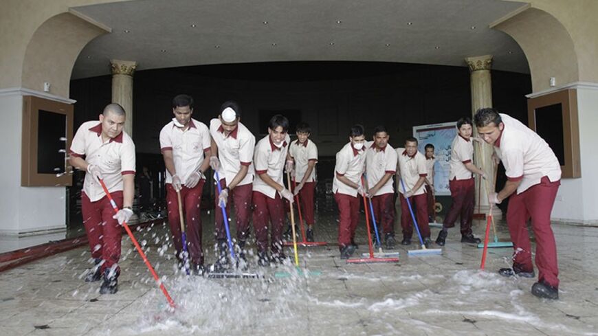Workers clean up at the Villaggio shopping mall in Doha, May 29, 2012. Thirteen expatriate children were among those killed in Monday's fire at the Villaggio Mall in Doha's west end, including two-year-old triplets from New Zealand. Authorities have ordered an investigation into the blaze near a childcare area at the mall amid reports that security staff at the complex reacted slowly to the blaze and in chaotic fashion. Several at the complex told Reuters fire alarms did not go off or rang only dimly.  REUT