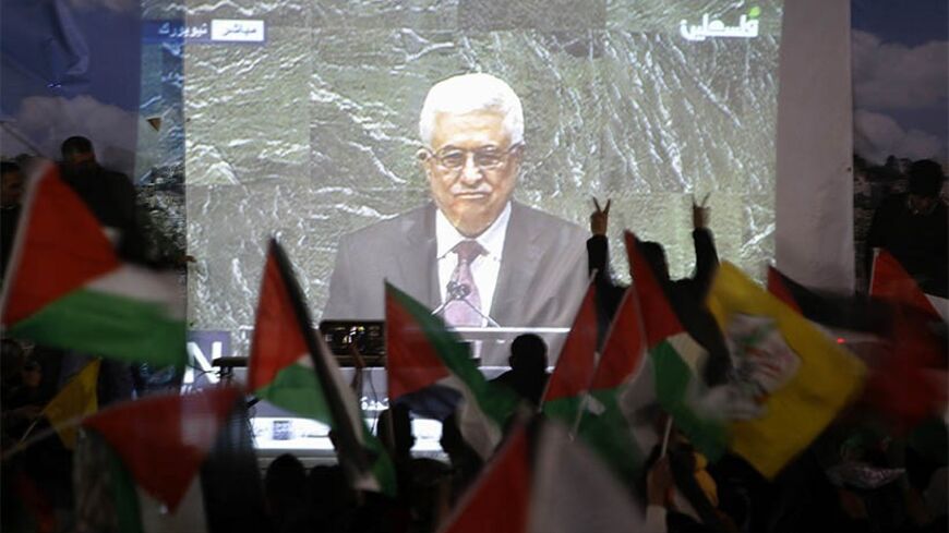 Palestinians take part in a rally while the speech of Palestinian President Mahmoud Abbas is being projected in the West Bank city of Ramallah November 29, 2012. The 193-nation U.N. General Assembly overwhelmingly approved a resolution on Thursday to upgrade the Palestinian Authority's observer status at the United Nations from "entity" to "non-member state," implicitly recognizing a Palestinian state. REUTERS/Mohamad Torokman (WEST BANK - Tags: POLITICS) - RTR3B1GJ