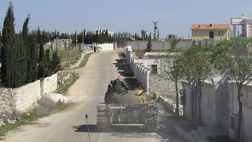 Free Syrian Army fighters ride a tank as they patrol a street in Rif al-Muhandisin at the Western countryside of Aleppo March 27, 2014. Picture taken March 27, 2014. REUTERS/Abdalghne Karoof (SYRIA - Tags: POLITICS CIVIL UNREST CONFLICT) - RTR3IYY0