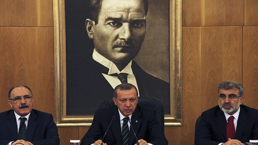 Turkey's Prime Minister Tayyip Erdogan, flanked by his deputy Besir Atalay (L) and Energy Minister Taner Yildiz (R), speaks during a news conference at Ataturk International airport in Istanbul April 4, 2014. Turkish Prime Minister Tayyip Erdogan called on Friday for the central bank to cut interest rates, sending the lira lower, and said he favoured keeping a three-term limit for ruling party deputies, suggesting he may run in August presidential polls. In his first public comments since a victory speech a