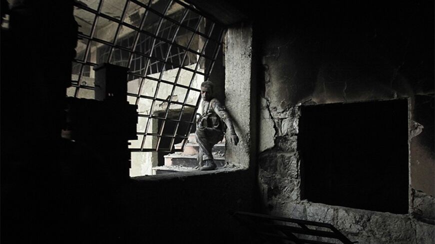 A wounded Islamist rebel fighter carries his weapon during what they said was a takeover of the Furn Al-Ali building that was under control by the Syrian regime in Ramouseh, an area located beside Aleppo Artillery school April 12, 2014. REUTERS/Ammar Abdullah (SYRIA - Tags: POLITICS CIVIL UNREST CONFLICT TPX IMAGES OF THE DAY) - RTR3L05C