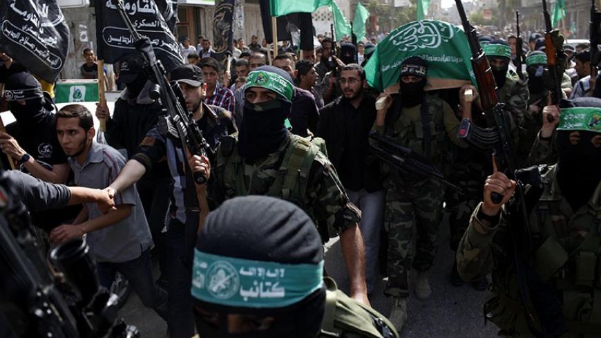 Palestinian Hamas militants carry a coffin containing the body of their fellow comrade Rami Meshmish during his funeral in the central Gaza Strip April 16, 2014. Meshmish and another fellow militant were killed in an accidental explosion on Wednesday, al-Qassam brigades, the armed wing of Hamas movement, said in a statement. REUTERS/Ibraheem Abu Mustafa (GAZA - Tags: POLITICS CIVIL UNREST) - RTR3LJNS