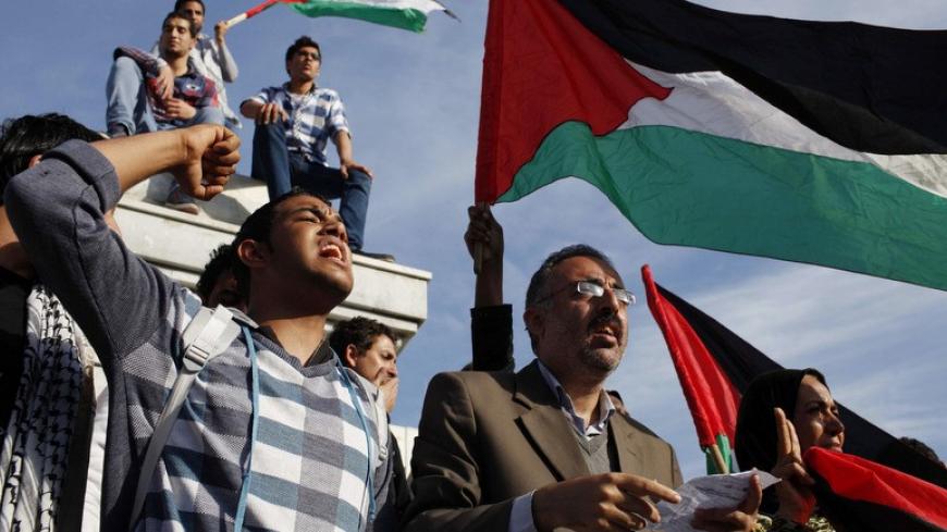 Palestinians wave national flags as they celebrate after an announcement of a reconciliation agreement in Gaza City April 23, 2014. The Gaza-based Islamist group Hamas and President Mahmoud Abbas's Palestine Liberation Organization (PLO) agreed on Wednesday to implement a unity pact, both sides announced in a joint news conference. REUTERS/Ibraheem Abu Mustafa (GAZA - Tags: POLITICS TPX IMAGES OF THE DAY) - RTR3MBX7