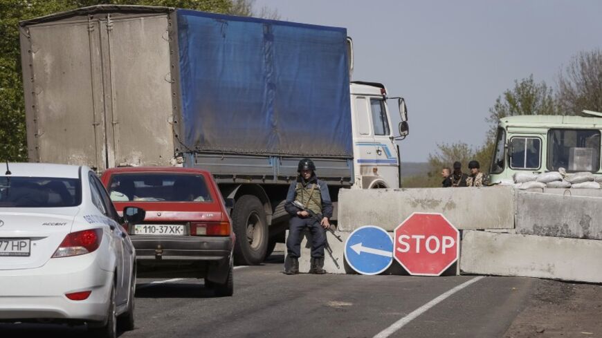 Ukrainian soldiers stand guard at a checkpoint outside the city of Slaviansk April 27, 2014. The leader of separatist rebels holding a group of international observers in the Ukrainian city of Slaviansk said he was scheduled on Sunday to meet a delegation of mediators who were on their way to negotiate the observers' release. REUTERS/Gleb Garanich (UKRAINE - Tags: POLITICS CIVIL UNREST) - RTR3MTAM