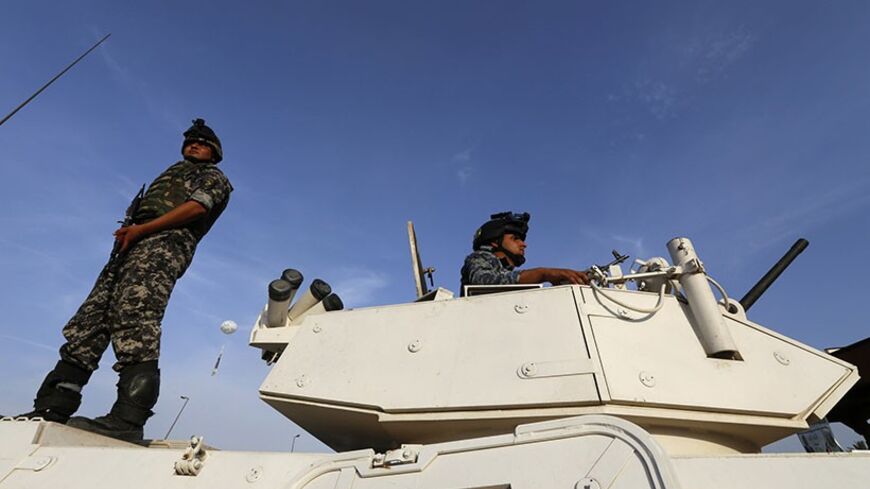 Iraqi security forces stand guard during an election campaign for candidates of Al-Sadiqoon in Baghdad, April 25, 2014. The elections, a key test for the country's fledgling democracy, will take place against a backdrop of increasing violence and fighting in western Anbar province to expel al-Qaeda linked groups. The run-up to the national election on April 30 has been marred by attacks. A series of explosions killed 28 people and wounded more than 40 at Asaib's rally in Iraq on Friday, police and medical s
