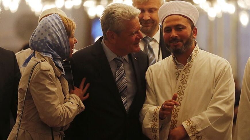 Germany's President Joachim Gauck (C) and his partner Daniela Schadt (L) listen to an Imam as they visit the Ottoman-era Sultanahmet mosque, known as Blue mosque, in Istanbul April 29, 2014. REUTERS/Murad Sezer (TURKEY - Tags: POLITICS RELIGION) - RTR3N4QT