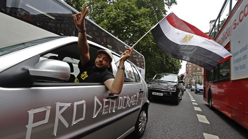 Supporters of deposed President Mohamed Mursi demonstrate as they slow drive through central London August 17, 2013. Supporters of Mursi fought a gunbattle with security forces in a Cairo mosque on Saturday, while Egypt's army-backed government, facing deepening chaos, considered banning his Muslim Brotherhood group. REUTERS/Luke MacGregor (BRITAIN - Tags: CIVIL UNREST POLITICS RELIGION) - RTX12OXK