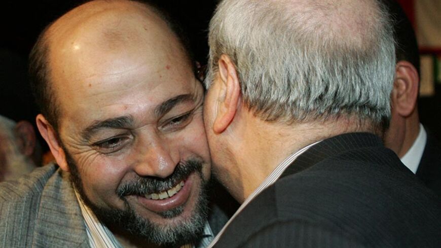 Mousa Abu Marzouk (L), a politburo member of Hamas, embraces Farouk Kaddoumi, Palestinian head of the political department of the Palestinian Liberation Organization (PLO) and a leader of the Fatah movement, at a ceremony for Palestinian Liberation Front (PLF) in a Palestine refugee camp near Damascus May 12, 2006. REUTERS /Khaled al-Hariri - RTR1DBFA