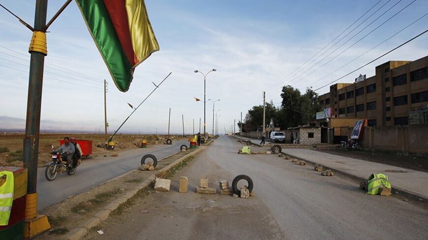 A security checkpoint guarded by Syrian Kurd Asaish officers (R) is seen at Derik in Al-Hasakah October 31, 2012. Iraqi Kurdish President Masoud Barzani warned Kurds in Syria against being sucked into the "fires of discord," urging them to preserve Kurdish unity as tensions between rival factions threaten to spillover into violence. Syria's Kurds see the war ravaging their country as an unprecedented opportunity to gain the kind of freedoms enjoyed by their ethnic kin in neighbouring Iraq, where they live a