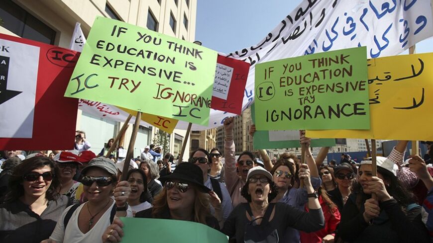 Teachers hold placards during a protest in front of the Grand Serail in Beirut, February 27, 2013. An open-ended strike by teachers and civil servants entered its second week today for the government to approve the wage hike proposal. REUTERS/Sharif Karim (LEBANON - Tags: POLITICS EDUCATION CIVIL UNREST) - RTR3ECE2