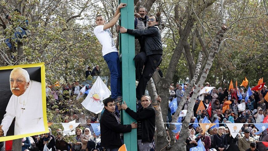A poster depicting U.S.-based Muslim cleric Fethullah Gulen as a pope, is seen as supporters of the ruling AK Party attend an election rally in Konya, central Turkey, March 28, 2014. Erdogan pulled out of election rallies in central Turkey on Friday in order to rest his voice after weeks of campaigning around the country, his office said. Erdogan had difficulty speaking at rallies in southeast Turkey on Thursday ahead of Sunday's local elections. Turkey will hold municipal elections on March 30. REUTERS/Umi