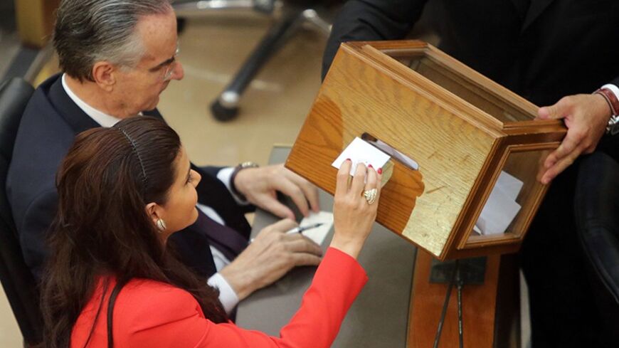 Lebanese Member of Parliament Sethrida Geagea (bottom), wife of presidential candidate Samir Geagea, casts her vote to elect the new Lebanese president in the parliament building in downtown Beirut April 23, 2014. Lebanese parliamentarians failed to elect a new president in a first round of voting on Wednesday, with leading candidate Samir Geagea falling well short of the required two-thirds majority. REUTERS/Joseph Eid/Pool    (LEBANON - Tags: POLITICS ELECTIONS) - RTR3MB3Q